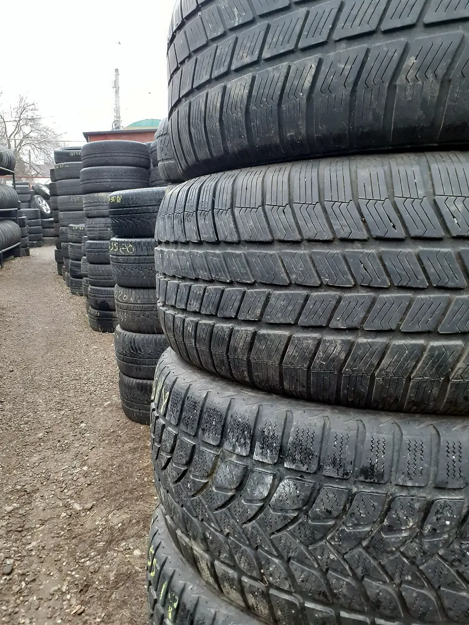 Stive de anvelope de iarnă second-hand în curtea depozitului